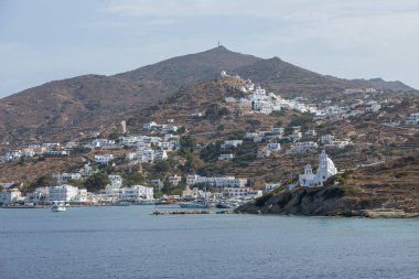 Chora, Ios Adası, Yunanistan - 26 Eylül 2020: liman manzarası ve Agia Irini, Saint Irene, Yunan Ortodoks kilisesi. Arka planda tepeler.