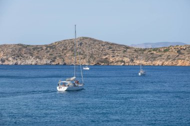 Chora, Ios Adası, Yunanistan - 26 Eylül 2020 Chora limanından kalkan tekne. Arkasında beyaz geleneksel binalar olan tepeler.