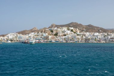 Naxos Adası, Yunanistan - 26 Eylül 2020 liman rıhtımına demirlemiş tekne ve yelkenli. Limanda beyaz geleneksel binalar. Arka planda tepeler.