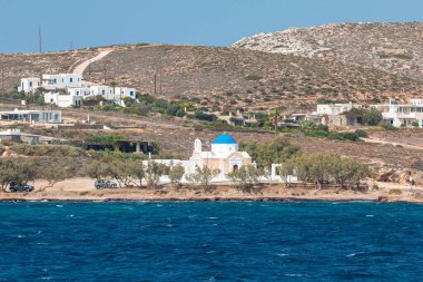 Paros Adası, Yunanistan - 26 Eylül 2020: Arka planda tepelerde geleneksel binalar bulunan liman manzarası.