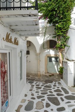 Parikia, Paros Adası, Yunanistan - 26 Eylül 2020: Dükkanları ve restoranı olan eski şehrin dar sokakları. Geleneksel, geniş mimari ve beyaz eklemli taş bir yol..