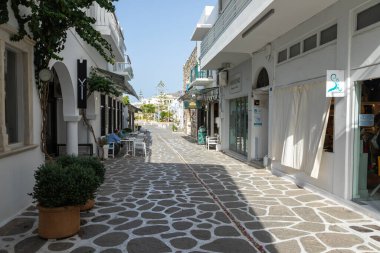 Parikia, Paros Adası, Yunanistan - 26 Eylül 2020: Dükkanları ve restoranı olan eski şehrin dar sokakları. Geleneksel, geniş mimari ve beyaz eklemli taş bir yol..