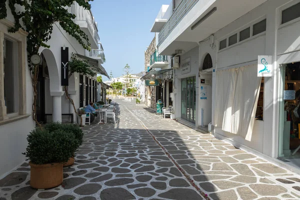 Parikia, Paros Adası, Yunanistan - 26 Eylül 2020: Dükkanları ve restoranı olan eski şehrin dar sokakları. Geleneksel, geniş mimari ve beyaz eklemli taş bir yol..