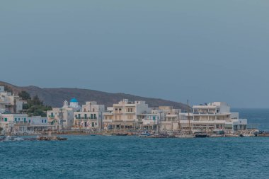 Piso Livadi, Paros Adası, Yunanistan - 26 Eylül 2020: Akşamları geleneksel beyaz binalarla liman manzarası. Aydınlanmalar.