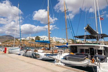 Piso Livadi, Paros Adası, Yunanistan - 27 Eylül 2020: Rıhtıma demirlemiş tekne ve yelkenli gemi. Beyaz geleneksel binalar.