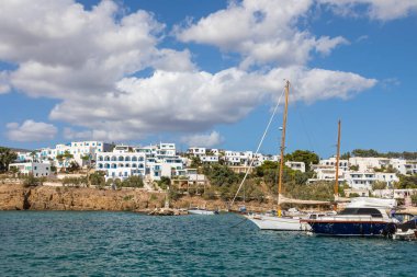 Piso Livadi, Paros Adası, Yunanistan - 27 Eylül 2020: Rıhtıma demirlemiş tekne ve yelkenli gemi. Beyaz geleneksel binalar.