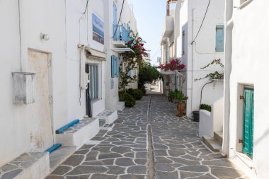 Piso Livadi, Paros Adası, Yunanistan - 27 Eylül 2020: Dükkanı ve restoranı olan eski şehrin dar sokakları. Geleneksel, geniş mimari ve beyaz eklemli taş bir yol..