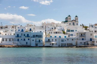 Naoussa, Paros Adası, Yunanistan - 27 Eylül 2020: Paros adasındaki küçük liman kasabasının manzarası. Tepedeki beyaz villalar, Naoussa Kilisesi, arkada Kimisis Theotokou..