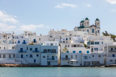 Naoussa, Paros Adası, Yunanistan - 27 Eylül 2020: Paros adasındaki küçük liman kasabasının manzarası. Tepedeki beyaz villalar, Naoussa Kilisesi, arkada Kimisis Theotokou..
