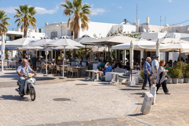 Naoussa, Paros Adası, Yunanistan - 27 Eylül 2020: Yerel restoranları olan liman kentinin ana meydanı. Misafirler için dışarıda masalar.