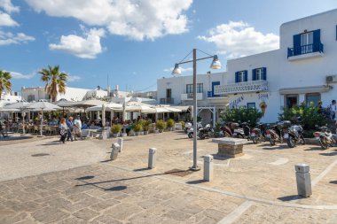 Naoussa, Paros Adası, Yunanistan - 27 Eylül 2020: Yerel restoranları olan liman kentinin ana meydanı. Misafirler için dışarıda masalar.