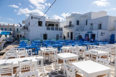 Naoussa, Paros Adası, Yunanistan - 27 Eylül 2020: Yerel restoranları olan balıkçı köyünün ana meydanı. Misafirler için dışarıda masalar.