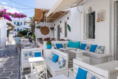 Naoussa, Paros Adası, Yunanistan - 27 Eylül 2020: Yerel restoranı ve dükkanları olan dar balıkçı köyü manzarası. Misafirler için dışarıda masalar.