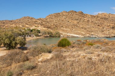 Monasteri Sahili, Paralia, Paros Adası, Yunanistan - 27 Eylül 2020: Paros 'un en popüler plajlarından biri. İnsanlar saman şemsiyeler altında güneşleniyorlar..