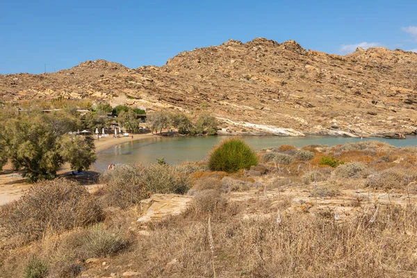 Monasteri Sahili, Paralia, Paros Adası, Yunanistan - 27 Eylül 2020: Paros 'un en popüler plajlarından biri. İnsanlar saman şemsiyeler altında güneşleniyorlar..