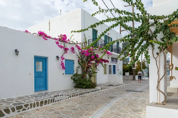 Antiparos Adası, Yunanistan - 28 Eylül 2020: Antiparos kentinin merkezinde geleneksel Yunan beyaz mimarisi. Pembe Bugenwilla çatıda..