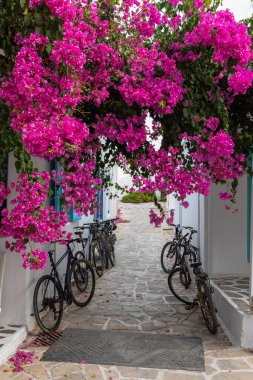 Antiparos Adası, Yunanistan - 28 Eylül 2020: Antiparos Adası 'nda dar bir cadde boyunca park edilmiş bisikletler. Yaz mevsimi.