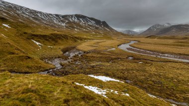 Angus 'taki karla kaplı tepelerin arasında bir dağ, kıvrılan bir nehir var. Kırsal alan. Aberdeenshire, İskoçya, İngiltere.