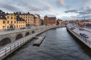 Stockholm, İsveç - 18 Nisan 2016: Kanal üzerindeki köprüden başkentin tarihi mimarisinin görüntüsü.