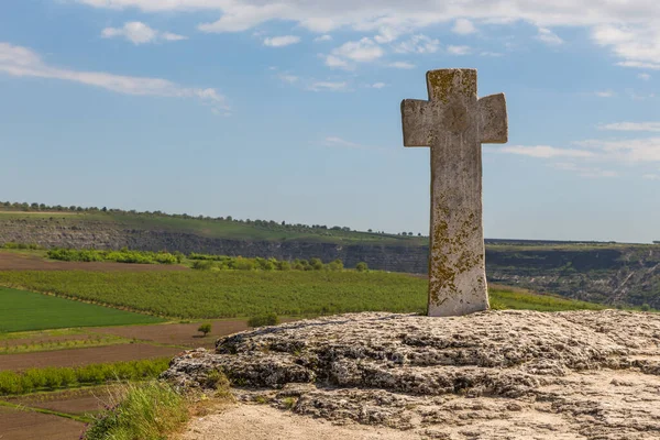 A view of the old cross at rock monastery Orheiul Vechi in Reut river valley in Trebujeni, natural landscape of limestone rock. Republic of Moldova.