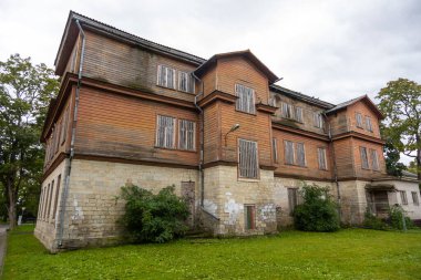 Saaremaa Adası, Kuressaare, Estonya 'da çimlerle çevrili tahta pencereli ve taş temeli olan eski ahşap bina..