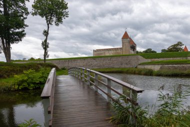 Hendeğin üzerindeki ahşap köprü Estonya 'nın Saaremaa kentindeki taş duvarlarla çevrili ortaçağ Kuressaare Kalesi' ne çıkıyor..