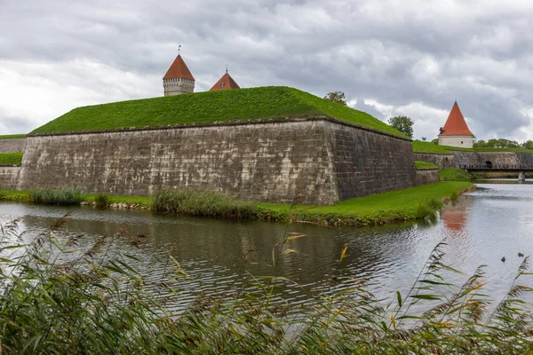 Estonya 'nın Saaremaa adasında hendek ve yeşilliklerle çevrili kırmızı çatılı kuleleri ve taş duvarları olan ortaçağ Kuressaare Kalesi.