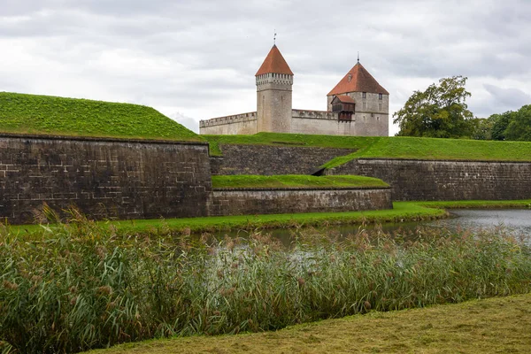 Estonya 'nın Saaremaa adasında hendek ve yeşilliklerle çevrili kırmızı çatılı kuleleri ve taş duvarları olan ortaçağ Kuressaare Kalesi.