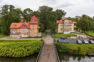 Kuressaare, Saaremaa, Estonya 25 Ağustos 2021: Kuressaare 'de yağmurlu bir günde kırmızı kiremitli ve restoran girişi olan tarihi Arensburg binasının manzarası.