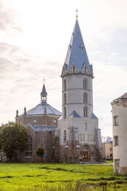 Narva, Estonya, 30 Ağustos 2021: St. Alexanders Kilisesi 'nin Narva' daki yumuşak sabah ışığı ile aydınlatılmış uzun taş bir kulesi ve metal çatısı var..