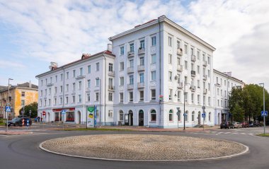 Narva, Estonya, 30 Ağustos 2021: Narva 'nın merkez meydanında bulunan kemerli zemin kat pencere ve balkonları olan klasik beyaz konut binası.