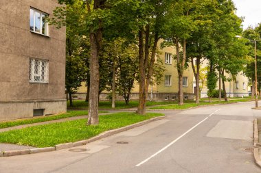 Narva 'da küçük bir sokak boyunca eski apartman binaları ve yeşil ağaçlarla dolu sessiz bir yerleşim yeri. Estonya.