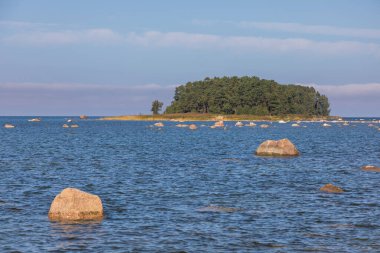 Denizde büyük kaya kütleleri ve Lahemaa Ulusal Parkı 'ndaki Baltık kıyısı boyunca uzanan çimenli bir patikası olan kıyı manzarası. Lahemaa, Estonya.