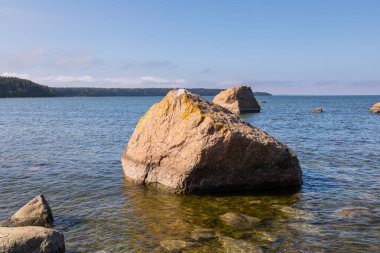 Denizde büyük kaya kütleleri ve Lahemaa Ulusal Parkı 'ndaki Baltık kıyısı boyunca uzanan çimenli bir patikası olan kıyı manzarası. Lahemaa, Estonya.