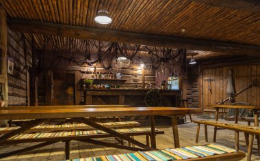 Lahemaa, Estonya, 31 Ağustos 2021: Lahemaa Milli Parkı 'ndaki kırsal bir meyhanenin içindeki ahşap bir masaya koyu bir bardak Saku birası yerleştirildi.