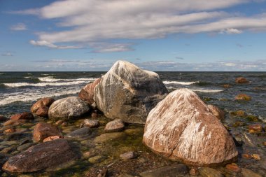 Estonya 'daki Lahemaa Ulusal Parkı' nda büyük kıyı kayaları ve dalgaların üzerinde yuvarlandığı Baltık Denizi kıyıları.