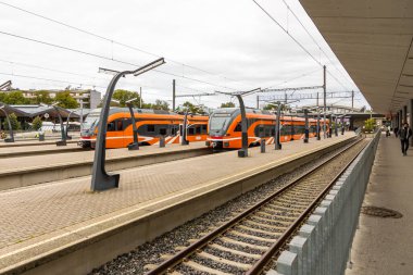 Tallinn Estonya 02 Eylül 2021: Turuncu banliyö trenleri bulutlu bir günde merkez tren istasyonunun platformlarında dururlar.