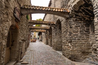 Tallinn, Estonya 2 Eylül 2021: Eski Şehir 'de kemerli ve kaldırım taşı yolu olan bir ortaçağ taş geçidine bakın.