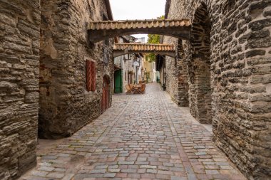 Tallinn, Estonya 2 Eylül 2021: Eski Şehir 'de kemerli ve kaldırım taşı yolu olan bir ortaçağ taş geçidine bakın.