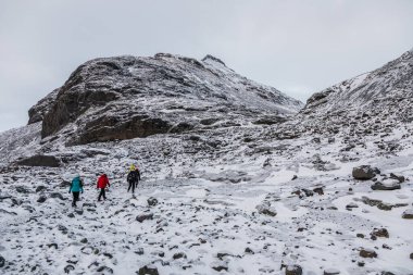 İzlanda, 2 Şubat 2022. Bir grup yürüyüşçü, Vatnajokull yakınlarındaki Mavi Buz Mağarası 'na yaklaşırken kayalık ve karla kaplı bir vadiye doğru ilerliyorlar..