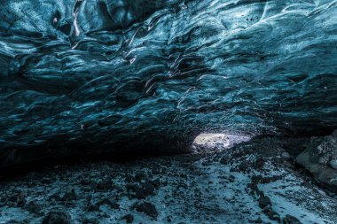 İzlanda 'daki Vatnajokull Ulusal Parkı' nın Mavi Buz Mağarası 'nın içinde yontulmuş buzul tavanı karlı bir zeminin üzerinde derin mavi buz oluşumlarını ortaya koyuyor..