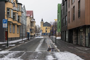 Reykjavik, İzlanda 05 Şubat 2022: Reykjavik 'teki donmuş Tjornin Gölü kıyısındaki modern binalara açılan köprü.