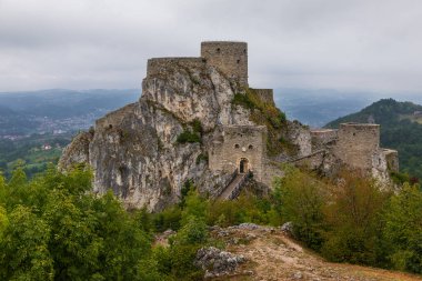 Bosna-Hersek 'in Srebrenik kentindeki kayalık bir tepeye inşa edilen ortaçağ taş kalesi, engebeli manzara ve yeşillik, tarihi mimari ve seyahat merkezleriyle çevrili..