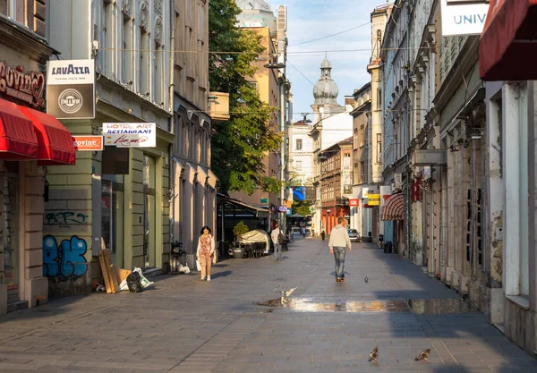 Saraybosna, Bosna-Hersek: 15 Ağustos 2022: Saraybosna şehir merkezinde tarihi dükkanlar ve mimari eserlerle Bascarsija 'nın eski bir kasabasında geleneksel bir cadde boyunca yürüyen insanlar.