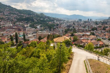 Saraybosna, Bosna-Hersek: 15 Ağustos 2022: Saraybosna 'nın panoramik manzarası, yoğun yerleşim bölgelerinin yeşil yamaçlara tırmandığını gösteriyor.