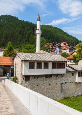 Konjiç, Bosna-Hersek: Geleneksel mimari ve cami minaresine sahip tarihi taş bina, Konjiç kentinin çatılarının üzerinde görülüyor.
