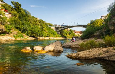 Bosna-Hersek 'in Mostar kenti 16 Ağustos 2022: Kalabalık, Mostar' ın arka planında tarihi binalar ve köprü bulunan bir uçurum dalış platformu yakınlarında toplandı.
