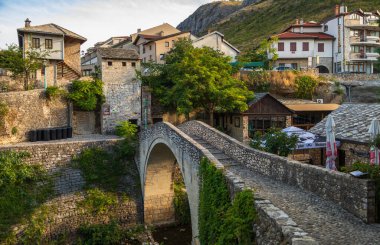 Mostar, Bosna-Hersek, 16 Ağustos 2022. Kriva Cuprija taş köprüsü ve tarihi kasaba bölgesindeki binalar.