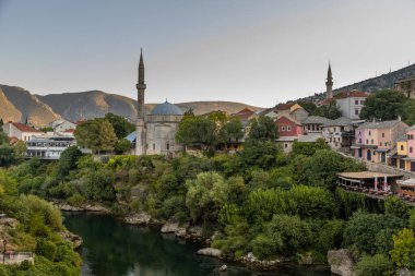 Mostar, Bosna-Hersek 17 Ağustos 2022: Eski Mostar kentindeki tarihi binalar, cami minareleri ve Neretva nehri manzarası.