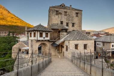 Bosna-Hersek 'in Mostar kenti 17 Ağustos 2022: Eski Mostar kentinde yamaç boyunca tarihi taş evler ve nehir kenarındaki kafeler inşa edildi.